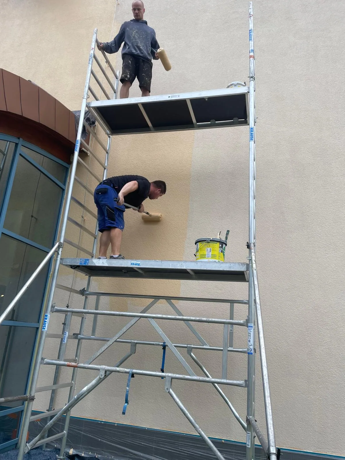 Pracovníci firmy na pojízdném lešení při práci na fasádě