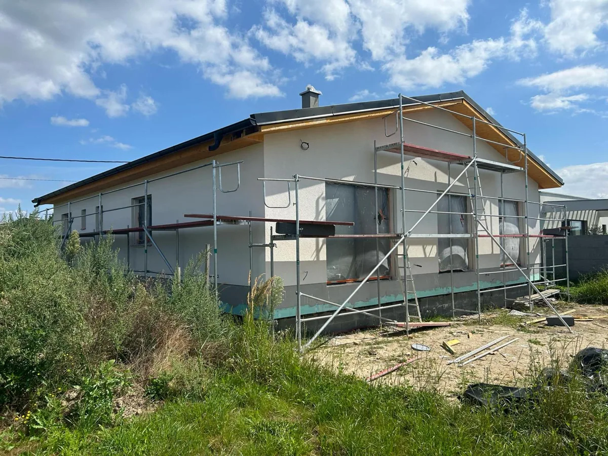 Dokončená novostavba bungalovu s bílou fasádou