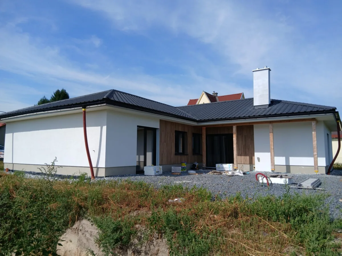 Dokončený bungalov s dřevěným obkladem a svahovanou terasou